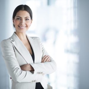 smiling female business leader with arms crossed scaled 300x300 1